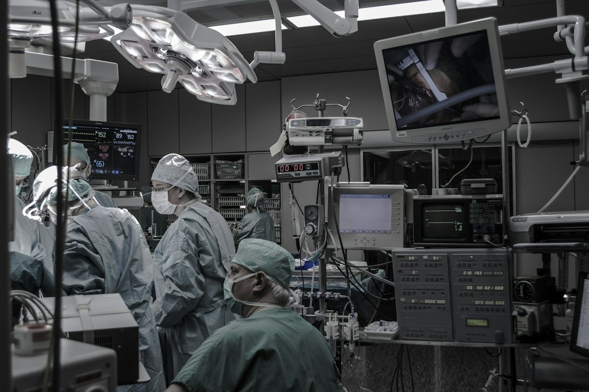 A surgical team working in an operating theatre surrounded by monitoring equipment