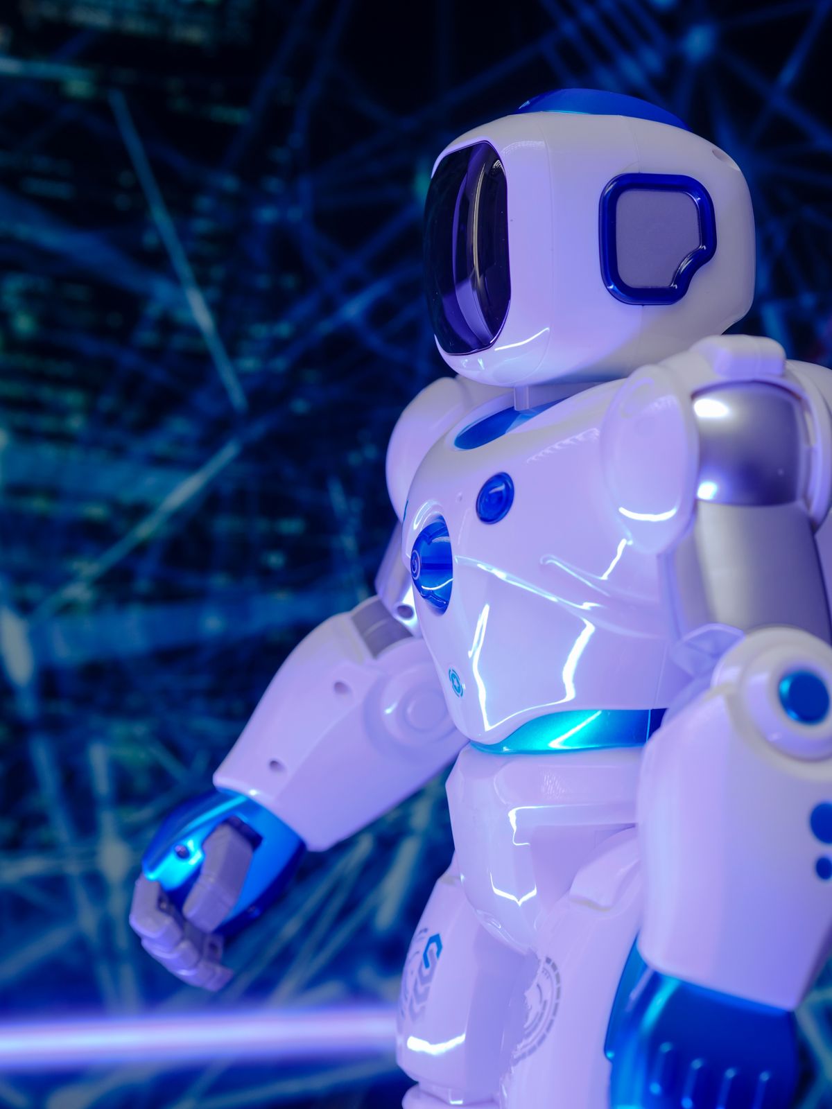 A small white robot lit in blue light